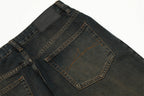 Close-up of dark blue jeans with a visible brand label on a white background