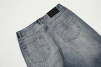Pair of blue jeans with a black label on a light gray background