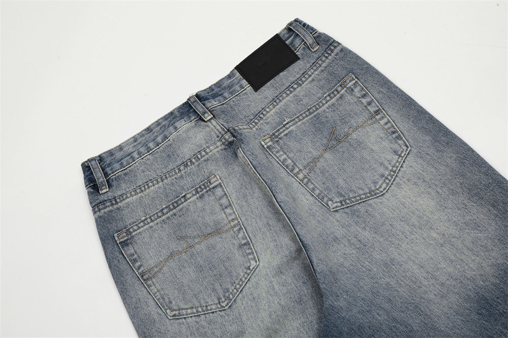 Pair of blue jeans with a black label on a light gray background