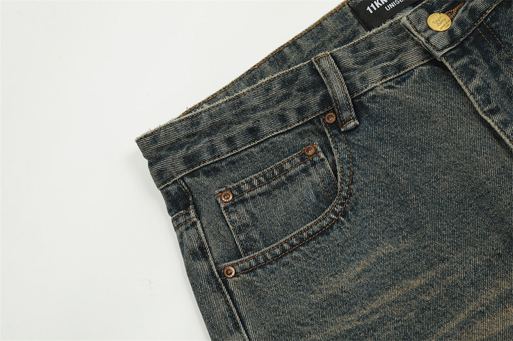 Close-up of blue jeans with a brand label on a light gray background