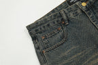 Close-up of blue jeans with a brand label on a light gray background