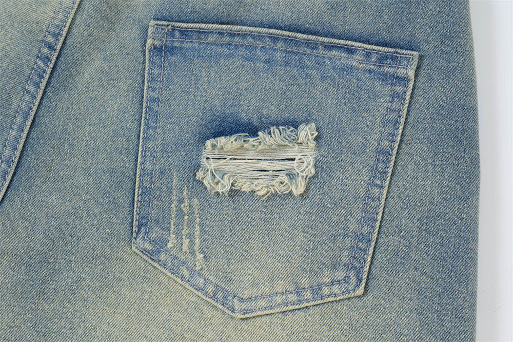 Close-up of a blue denim pocket with a decorative lace patch.