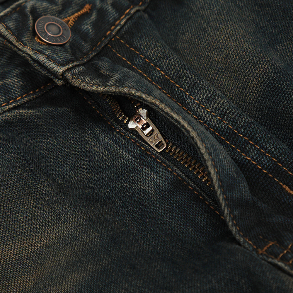 Close-up of a zipper on a pair of dark blue jeans.