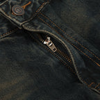 Close-up of a zipper on a pair of dark blue jeans.