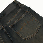 Close-up of dark blue jeans with a brand label on a white background