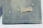 Close-up of a distressed denim jacket with frayed edges on a white background