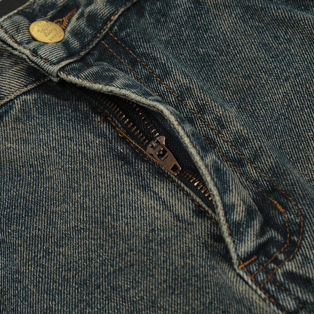 Close-up of a blue denim jacket with a zipper and button detail.