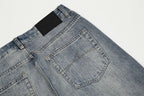 Close-up of a pair of blue jeans with a black label on a light gray background
