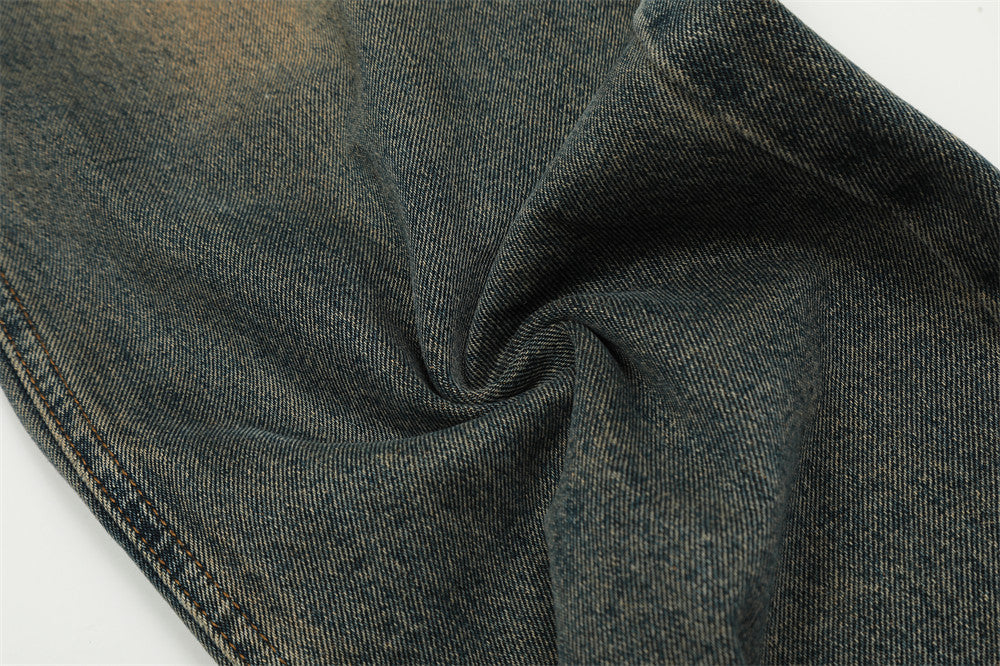 Close-up of dark denim fabric with visible texture and color variations.