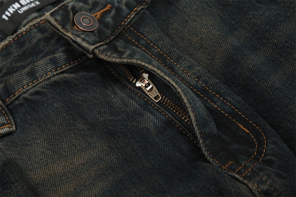 Close-up of dark blue denim fabric with a zipper and button detail.