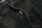 Close-up of dark blue denim fabric with a zipper and button detail.